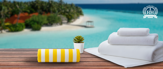 Luxury white spa towels neatly rolled on a wooden shelf